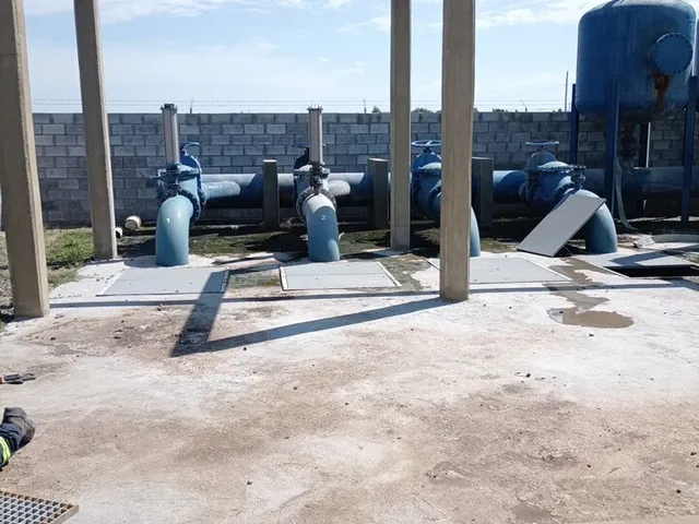 Planta de bombeo con cañerías azules y tanque hidroneumático a cielo abierto