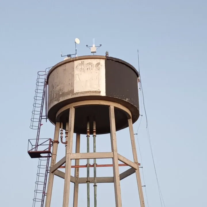 Tanque elevado de agua con antena y sensores instalados en la parte superior