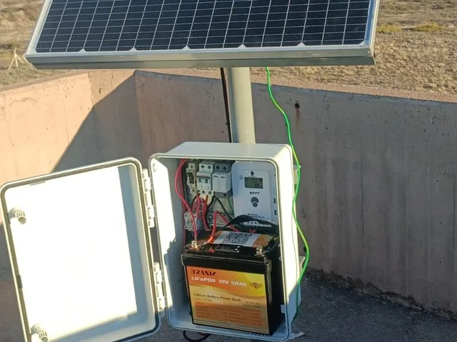 Técnico trabajando junto a una estación de monitoreo con panel solar y gabinete en la meseta