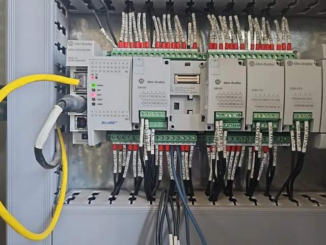 Tablero de control abierto con controlador, módulos de comunicación y borneras cableadas